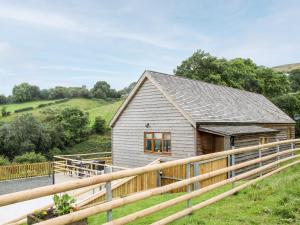 a barn conversion with a wooden fence around it at Toot View in Ludlow