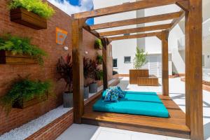 pergola na patio z niebieską kanapą w obiekcie Mood Independência - Aptos centrais e completos w mieście Passo Fundo