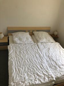 an unmade bed with white sheets and pillows at Kapitänshaus Scharmberg, Ferienwohnung Kormoran in Born