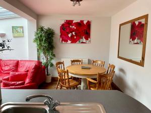 a living room with a table and a red couch at Somers House - pet friendly & parking in Portsmouth +33 photos
