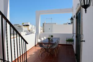ein Balkon mit einem Tisch und Stühlen auf einem Balkon in der Unterkunft Casas de Mar - Casa Coral in Olhão