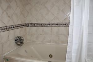 eine weiße Badewanne im Bad mit einem Duschvorhang in der Unterkunft Casas de Mar - Casa Coral in Olhão + 24 Fotos