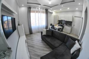 ein Wohnzimmer mit einem Sofa und einer Küche in der Unterkunft M&M’s Home in Terni