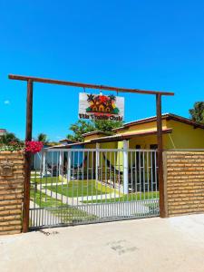 een gebouw met een wit hek en een bord bij Vila Vintém Chalés in Praia de Moitas