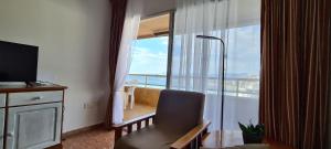 a room with a chair and a window with a view of the ocean at Apartamentos Florazar II in Cullera