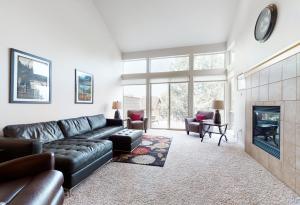 a living room with a leather couch and a fireplace at Pines and Blue Skies in Redmond