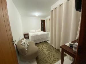 Habitación de hotel con cama y silla en Sol & Mar Pousada e Hospedaria, en Trancoso