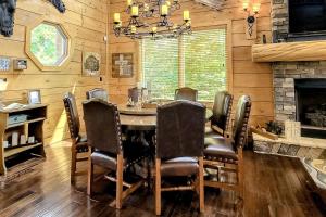 une salle à manger avec une table, des chaises et une cheminée dans l'établissement High Mountain Dream, à Gatlinburg