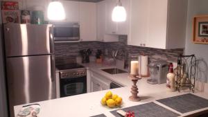 a kitchen with a refrigerator and a bowl of fruit on a counter at Luxury Sapphire Beach Resort and Marina 1BR VII in East End