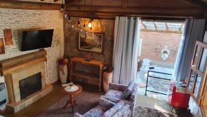 a living room with a couch and a fireplace at Pousada Alto da Neblina in Monte Verde
