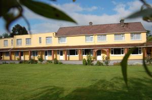 a large yellow building with a large yard at The Gardens guest accommodation in Killarney