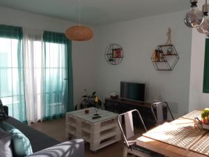 een woonkamer met een bank en een tafel bij Apartamento Maresia in Puerto del Carmen