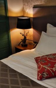 a bed with a lamp on a night stand next to it at Hoffmann Residence in Svetlogorsk