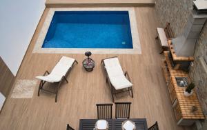uma vista superior de uma piscina com mesas e cadeiras em Villa turmero em Puerto del Rosario