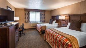 a hotel room with two beds and a television at Best Western Plus Flathead Lake Inn and Suites in Kalispell