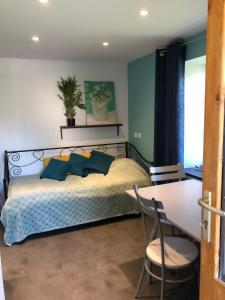 a bedroom with a bed and a table and chairs at Chez Fabrice in Le Pertuis