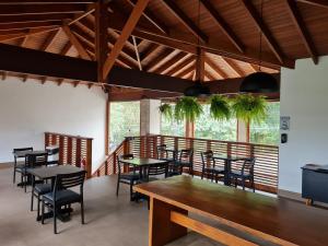 a dining room with tables and chairs and windows at Pousada Vila Ipuan in Pauba