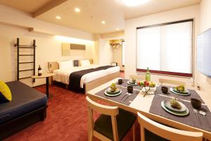 une chambre d'hôtel avec une table à manger et un lit dans l'établissement MONday Apart Premium KYOTO Station, à Kyoto