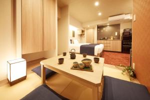 a room with a bed and a table with cups on it at MONday Apart Premium KYOTO Station in Kyoto