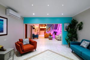una sala de estar con sillas y escaleras azules y naranjas. en Victoria City Hotel en Oranjestad