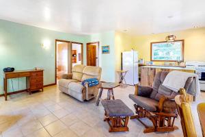 a living room with a couch and a kitchen at Three Little Birds in Caye Caulker