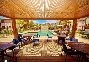 um pátio com mesas e cadeiras e uma piscina em Barra Grande Condomínio de Alto Padrão na Vila em Barra Grande