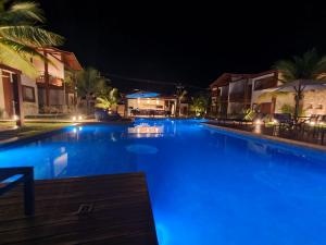 una gran piscina por la noche con luces azules en Barra Grande Condomínio de Alto Padrão na Vila en Barra Grande