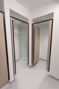 
a bathroom with a mirror and a shower stall at Hotel Give in Christchurch
