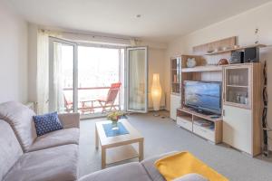 un soggiorno con un divano e una televisione di Hafenflair a Husum