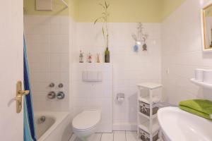 un bagno bianco con un water e un lavandino di Hafenflair a Husum Altre 13 foto