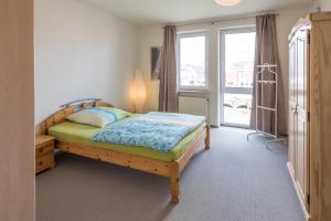 una camera da letto con un letto di legno e una finestra di Hafenflair a Husum