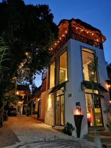 um edifício branco com luzes acesas à noite em Hotel Diosa del Agua Bacalar em Bacalar