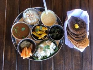 a plate of food with different types of food on a table at Blue Mountain Village Cottage in Nainital