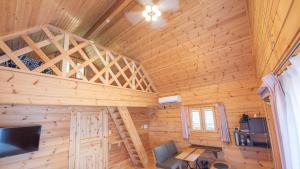 ein Holzzimmer mit einer Wendeltreppe in einer Hütte in der Unterkunft ロガシス石垣野底ヴィラ in Ibaruma