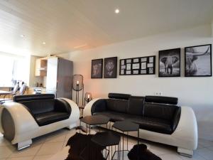 a living room with two black and white couches and tables at Cozy home with view and hottub in Rochehaut