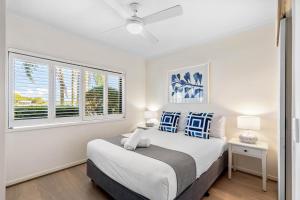 Habitación blanca con cama y ventana en Culgoa Point Beach Resort, en Noosa Heads
