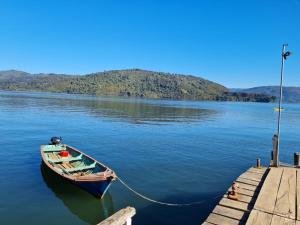 een boot vastgebonden aan een steiger op een meer bij Hostel Isla del Rey in Valdivia