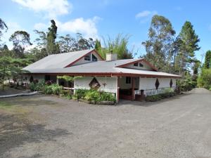 uma casa com um telhado de metal numa entrada em Lokahi Lodge em Volcano