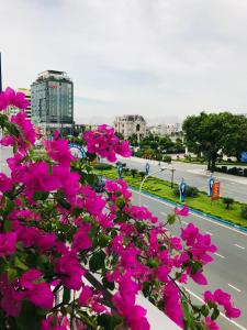 a bunch of pink flowers in front of a street at Lagalo Hotel Ha Nam in Phủ Lý