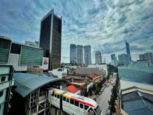 a train pulls into a train station in a city at Hotel Sentral Kuala Lumpur at KL Sentral Station in Kuala Lumpur