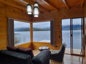 - un salon avec une grande fenêtre donnant sur l'eau dans l'établissement Cabañas de descanso, arcoiris del lago 1, à El Encano