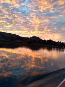 a reflection of a sunset in a body of water at Cabañas de descanso, arcoiris del lago 1 in El Encano