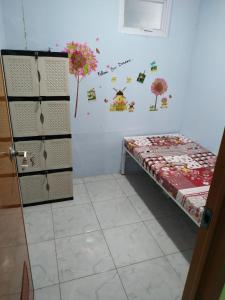 a room with a bed next to a wall with flowers at Eiffel Residence Petojo - Female Only in Jakarta