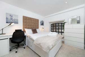 um quarto com uma cama, uma secretária e uma cadeira em DUPLEX 2 Bedr, 3 Beds, 2,5 Bath Trafalgar Square em Londres