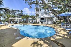 una gran piscina con sillas y sombrilla en Luxury Townhouse with Ocean Views - Walk to Ocean!, en Kure Beach