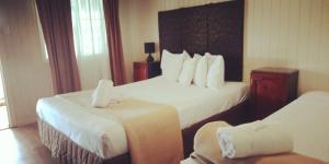 een hotelkamer met 2 bedden en een stoel bij Country Plaza Motor Inn in Mackay