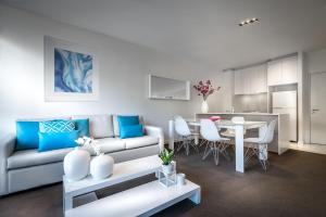 - un salon avec un canapé et une table dans l'établissement Milano Serviced Apartments, à Melbourne