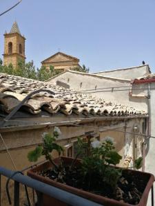 ein Gebäude mit einem Kacheldach mit Pflanzen darauf in der Unterkunft Antichi Quartieri in Piazza Armerina