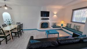 un soggiorno con divano, tavolo e camino di Casa da Praia by Sunny Deluxe ad Albufeira