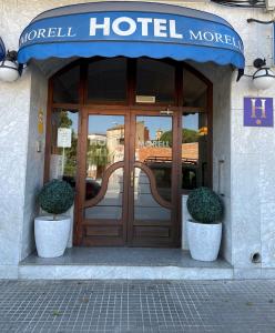 eine Tür zu einem Hotel mit zwei Topfpflanzen davor in der Unterkunft HOTEL MORELL in El Morell